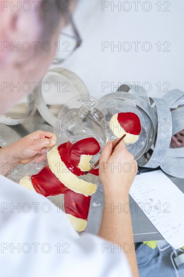 Person paints a Santa Claus mold with red and white tint, Christmas baking, Haselstaller Hof, Wildberg, Germany