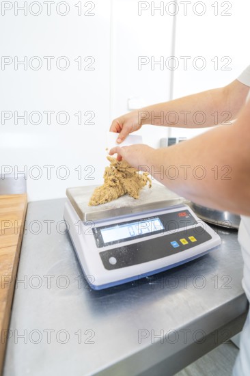 Person molding dough on a kitchen scale in a bright kitchen, Christmas baking, Haselstaller Hof, Wildberg, Germany