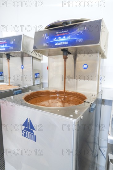 Chocolate flows from a machine into a metallic container, Weihnachtsbacken, Haselstaller Hof, Wildberg, Germany