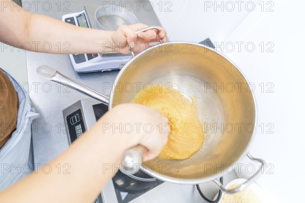 A person works with dough in a pan on a stove, Christmas baking, Haselstaller Hof, Wildberg, Germany