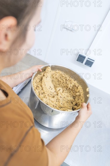 A person holds a large mixing bowl with dough in a kitchen, Christmas baking, Haselstaller Hof, Wildberg, Germany