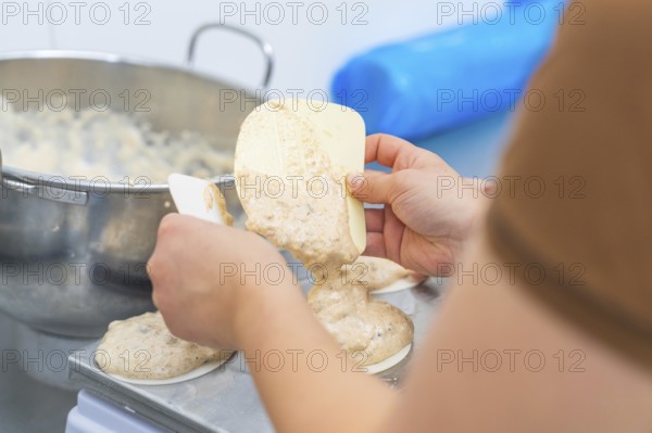 Two hands working with a dough and a silicone spatula on a kitchen table, Christmas baking, Haselstaller Hof, Wildberg, Germany