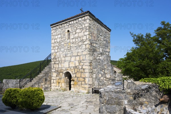 Historic stone tower with small garden and side stairs in a quiet area, Motsameta monastery, near Kutaisi, Imereti region, Georgia