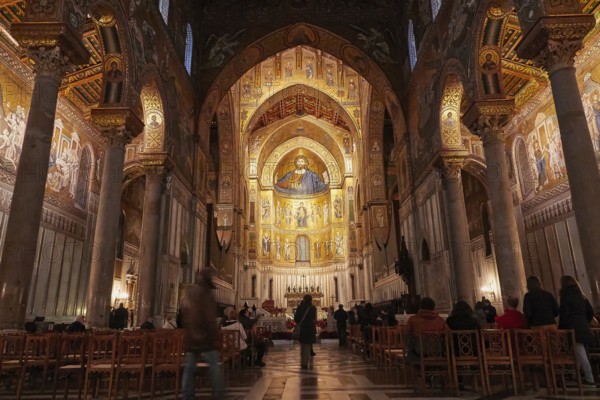 Magnificent sacral interior of a church with mosaics and golden decorations, filled rows of seats, Monreale, cathedral, UNESCO World Heritage Site, Sicily, Italy