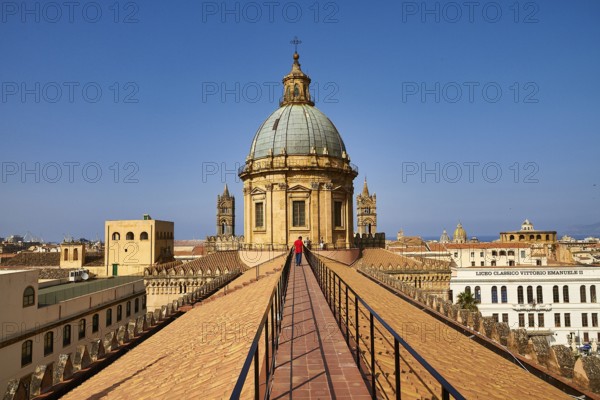 A person walks on a roof in Palermo to the historic dome with clear sky in the background, Palermo, Cathedral, UNESCO World Heritage Site, Sicily, Italy