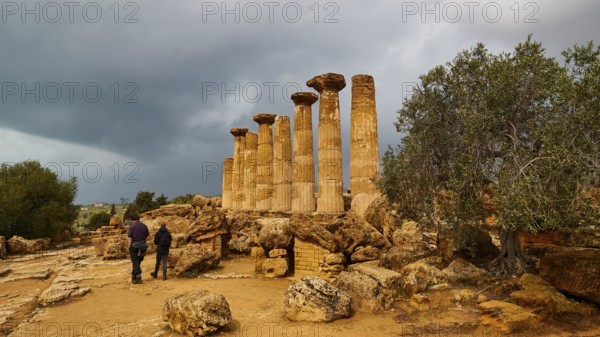 Heracles Temple, Ancient Column Ruins with Two People and Stormy Sky, Valley of the Temples, Valle dei Templi, Archaeological Site, UNESCO World Heritage Site, Agrigento, Sicily, Italy