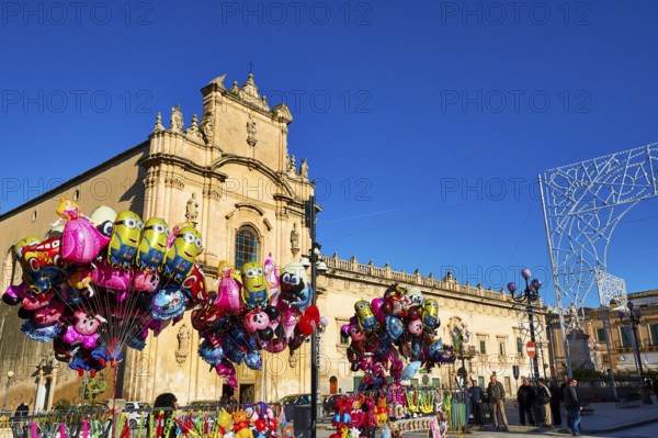 Scigli, Easter Sunday, colorful balloons in front of a church on a busy square with bright blue sky, Baroque towns of Sicily, Baroque corner of Sicily, late Baroque towns of Val di Noto, UNESCO World Heritage Site, Sicily, Italy