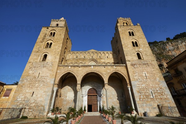 Impressive cathedral with symmetrical towers and arches under clear blue sky, Cefalu, cathedral, UNESCO World Heritage Site, Sicily, Italy