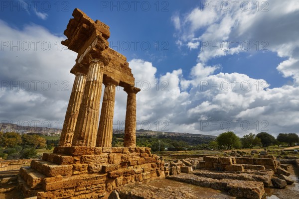 Temple of Dioscuren, ancient temple ruins on a hill under cloudy sky, Valley of the Temples, Valle dei Templi, Archaeological Site, UNESCO World Heritage Site, Agrigento, Sicily, Italy
