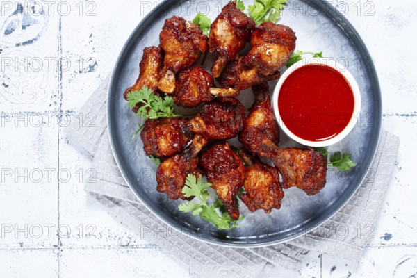 Crispy pieces of fried chicken, on a plate with sauce and herbs, in a modern kitchen environment, there are no people