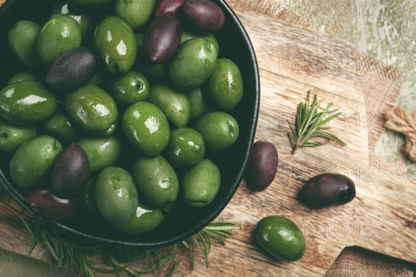Chalkidiki olives, classic Greek green olives, in a bowl on a cutting board, top view, without people