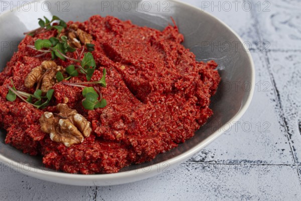 Mahammara red pepper sauce, with walnuts, and sprigs of fresh microgreens, homemade, no people