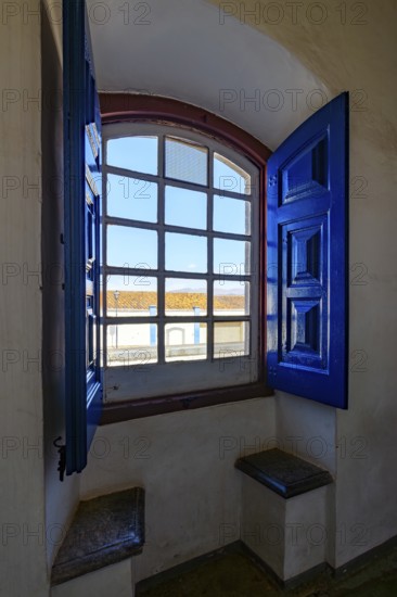 Colonial house in the city of Congonhas seen through the window of a historic Baroque church, Congonhas, Minas Gerais, Brazil