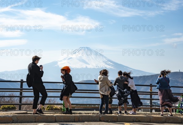 Tourists enjoy the view and take pictures, view of the snow-covered summit of Mount Fuji volcano in spring, Owakudani, Hakone, Japan