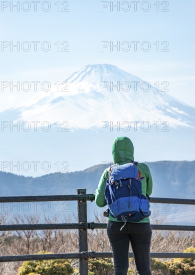 Tourist enjoying the view of the snow-covered summit of Mount Fuji volcano in spring, Owakudani, Hakone, Japan