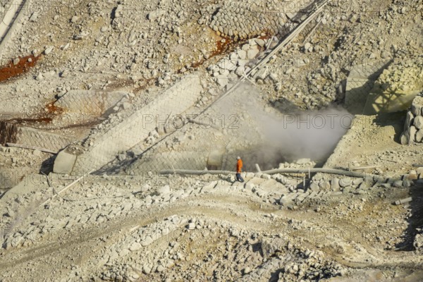Workers among steaming fumaroles in the Owakudani geothermal area at Komagatake volcano, Hakone, Japan