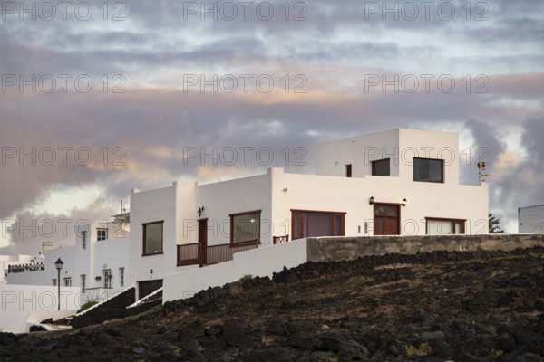 Typical white houses in the town of La Santa, at sunset, black volcanic rocks, Lanzarote, Canary Islands, Spain