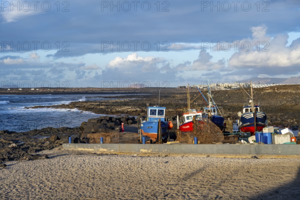 Colourful fishing boats at the port of La Santa, coast with volcanic rocks, La Santa, Lanzarote, Canary Islands, Spain