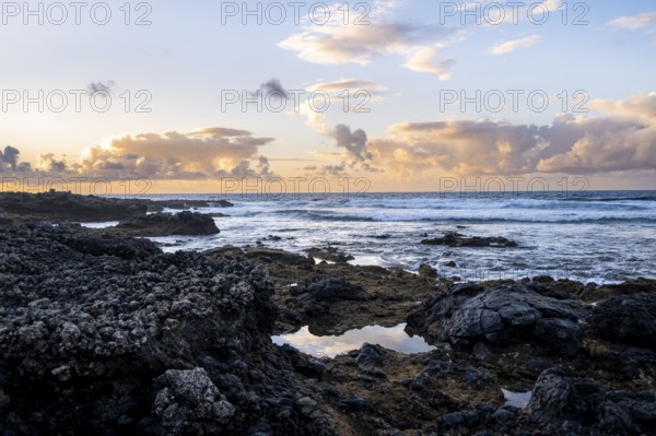 Seaside coast with volcanic rocks at sunset, La Santa, Lanzarote, Canary Islands, Spain