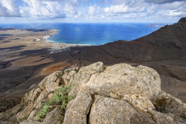 View from the Risco de Famara cliffs to the coast and the sea with the Famara beach, Playa de Famara, Lanzarote, Canary Islands, Spain