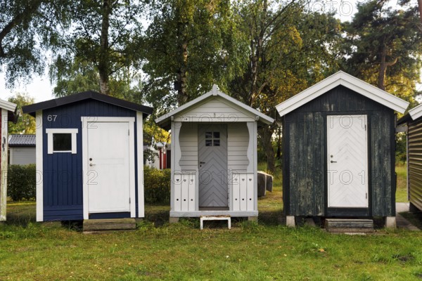 Three different beach huts in a meadow, Ystad, Sweden