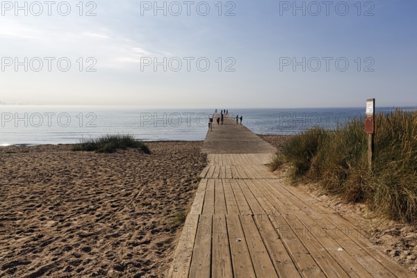 Wooden walkway on the beach, bathers on the horizon, summer in Ystad, Baltic Sea, Sweden