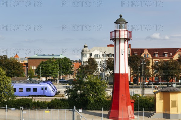Ystad lighthouse, octagonal iron tower standing between ferry terminal and train station, national monument, local train, Ystad, Sweden