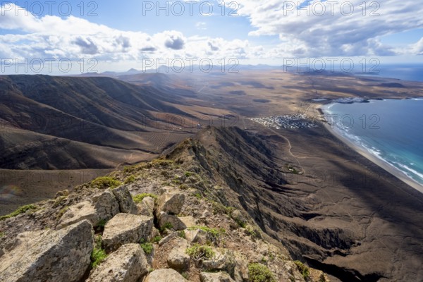 Castillejo viewpoint, view from the Risco de Famara cliffs to the coast and the sea with the Famara beach, Playa de Famara, Lanzarote, Canary Islands, Spain