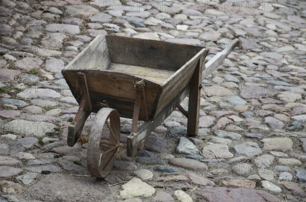 Old-fashioned wheelbarrow on paving stones in Den gamle by, The old village, open air museum in Odense, Fyn island, Fuen, Denmark, Scandinavia