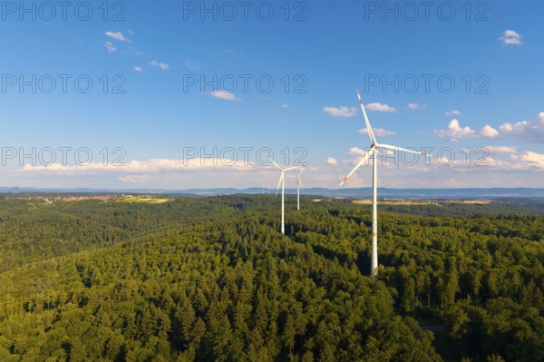 Wind turbines over green forest area, surrounded by beautiful clouds under a blue sky, near Schorndorf, Rems-Murr-Kreis, Baden-Württemberg, Germany