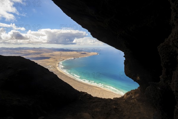 Cueva de las Cabras cave, view from the Risco de Famara cliffs on Famara beach, Playa de Famara with La Calaeta, Lanzarote, Canary Islands, Spain