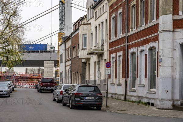 Residential buildings, directly on the A40 Neuenkamp bridge, in Duisburg-Homberg, pillars and cables of the new motorway bridge across the Rhine near Duisburg, construction phase of the 2nd bridge structure, North Rhine-Westphalia, Germany
