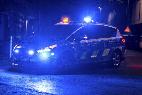 Police patrol car deployed with flashing lights, Essen, North Rhine-Westphalia, Germany