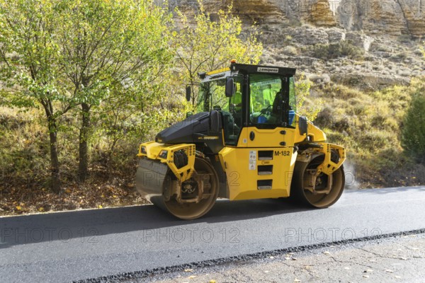 BOMAG compactor machine asphalt road construction resurfacing tarmac in rural area, near Albarracin, Teruel province, Aragon, Spain
