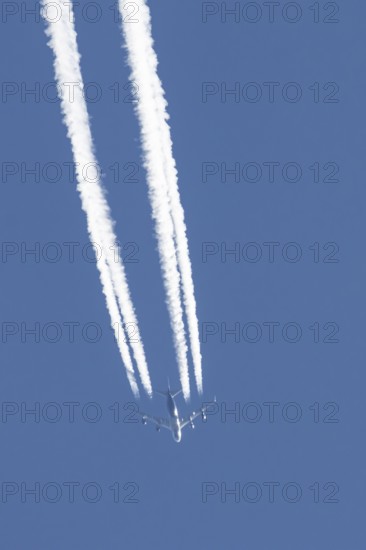 Boeing 747 jumbo jet cargo aircraft of Atlas air airlines flying in a blue sky with contrails or vapour trails behind, England, United Kingdom