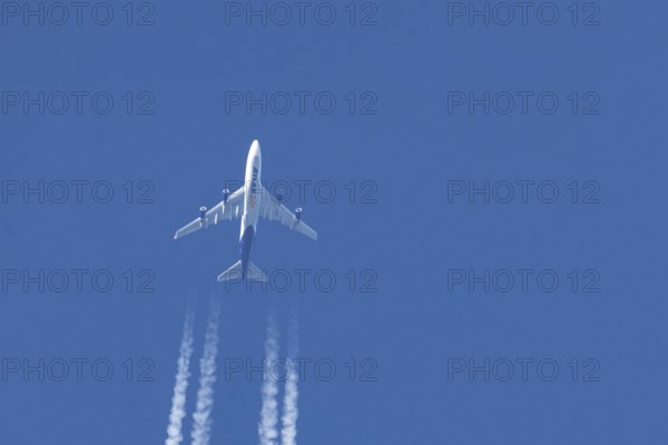 Boeing 747 jumbo jet cargo aircraft of Atlas air airlines flying in a blue sky with contrails or vapour trails behind, England, United Kingdom