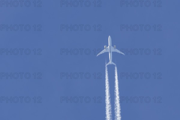 Boeing 787-9 Dreamliner jet passenger aircraft of Gulf Air airlines flying in a blue sky with contrails or vapour trails behind, England, United Kingdom