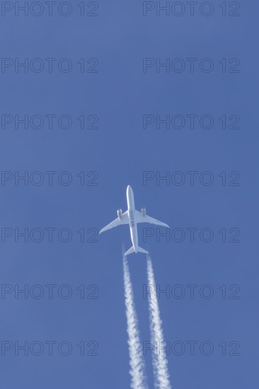 Boeing 787-9 Dreamliner jet passenger aircraft of Gulf Air airlines flying in a blue sky with contrails or vapour trails behind, England, United Kingdom