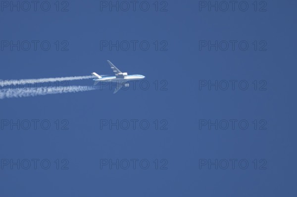 Airbus jet passenger aircraft of Royal Dutch KLM airlines flying in a blue sky with contrails or vapour trails behind, England, United Kingdom
