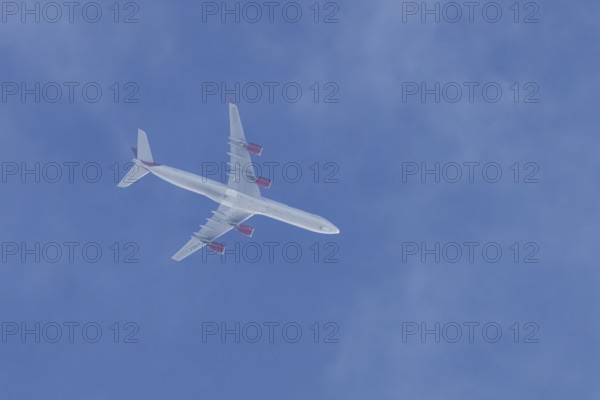 Airbus A340 jet cargo aircraft of European Cargo airlines flying in a blue sky, England, United Kingdom