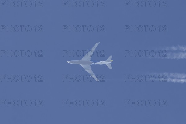 Boeing 747 jumbo jet cargo aircraft flying in a blue sky with contrails or vapour trails behind, England, United Kingdom