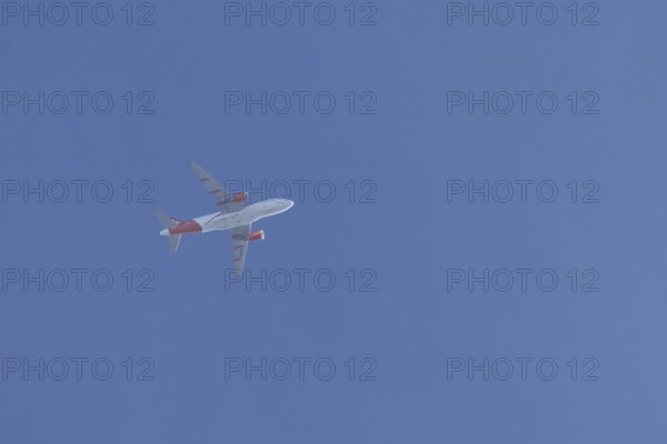 Airbus jet passenger aircraft of Easyjet airlines flying in a blue sky, England, United Kingdom