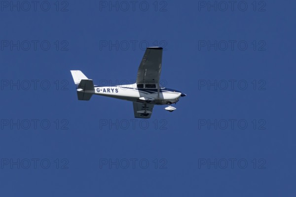 Cessna 172C Skyhawk light aircraft flying in a blue sky, England, United Kingdom