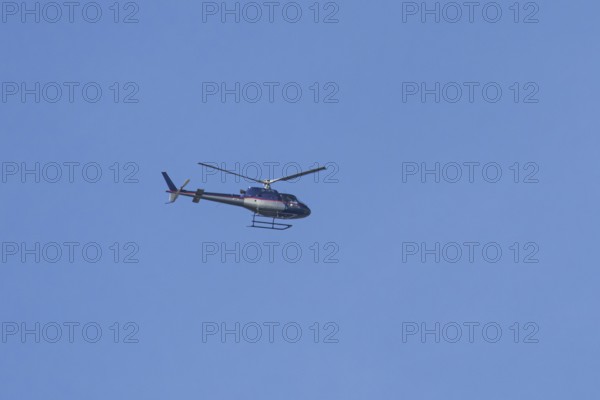 Airbus H125 helicopter flying in a blue sky, England, United Kingdom