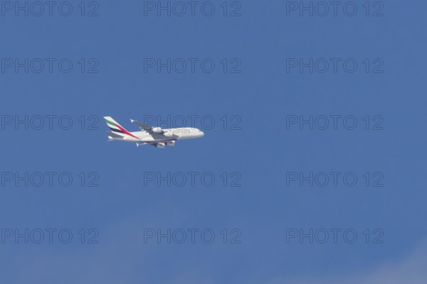 Airbus A380 jet passenger aircraft of Emirates airlines flying in a blue sky, England, United Kingdom
