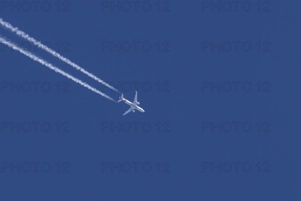 Airbus jet passenger aircraft of Eurowings airlines flying in a blue sky with contrails or vapour trails behind, England, United Kingdom