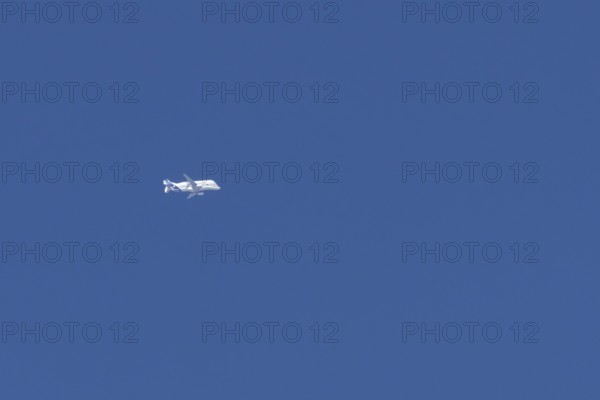 Airbus A330-743L Beluga XL cargo jet aircraft flying in a blue sky with white clouds, England, United Kingdom