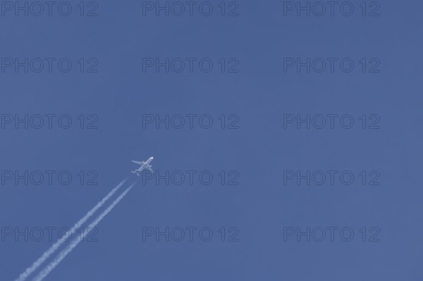 Airbus jet passenger aircraft of Eurowings airlines flying in a blue sky with contrails or vapour trails behind, England, United Kingdom