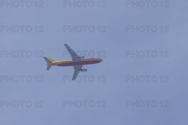 Boeing 767 jet cargo aircraft of DHL airlines flying in a blue sky, England, United Kingdom