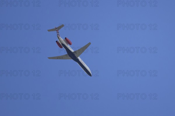 Embraer ERJ-145 jet passenger aircraft of Loganair airlines flying in a blue sky, England, United Kingdom